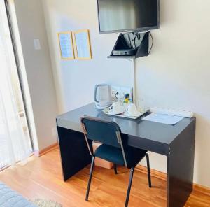 a black desk with a chair in a room at Boikhutsong Guest House in Maseru