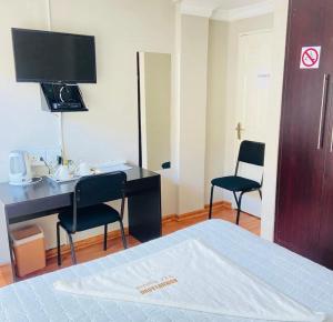 a hotel room with a desk and two chairs at Boikhutsong Guest House in Maseru