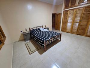 a bedroom with a bed with a blue and white comforter at la Citronnelle in Oualidia