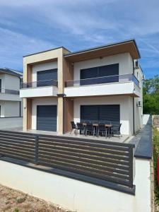a house with a deck with tables and chairs at Casa Lavinia in Bregvija