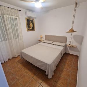 a bedroom with a bed in a white room at Picasso Beach House in Oliva +44 photos