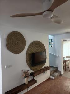 a living room with a flat screen tv on a wall at Picasso Beach House in Oliva