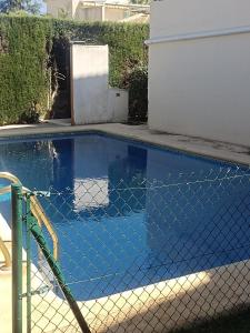a swimming pool with a chain link fence around it at Picasso Beach House in Oliva