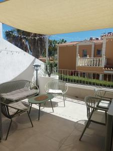 a patio with chairs and a table and a house at Picasso Beach House in Oliva