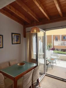 a dining room with a green table and a patio at Picasso Beach House in Oliva