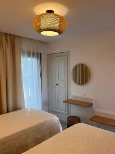 a bedroom with two beds and a light fixture at Fotinos House Skiathos in Skiathos