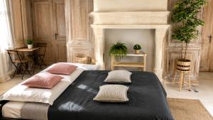 a bedroom with a large bed with pillows on it at Le Jardin de Villevaudé, proche Disney & Paris in Villevaudé