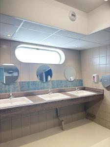 a bathroom with three sinks and a large mirror at Nuit insolite voilier in Le Havre
