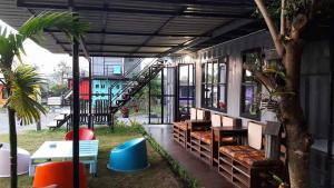 a building with a bench and a tree in a yard at Smile Box Coffee & Resort in Ban Nong Hin
