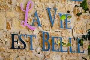 a wall with a pink ribbon and the words a new best baby at Maison d'Hôte la Vie Est Belle in Lalinde