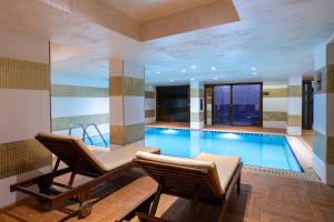 a large swimming pool with two chairs and a table at Great Fortune Concept Hotel in Istanbul