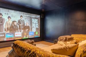 a room with a large screen with a couch and a tv at Villa ROYA in Saint-Florent