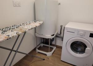 a laundry room with a washing machine next to a washer at Le Logis du Donjon 2 in Les Herbiers