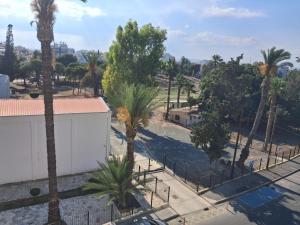 a view of a street with palm trees and a fence at Kay-Stay in Larnaca