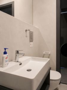 a bathroom with a white sink and a toilet at Kay-Stay in Larnaca +8 photos