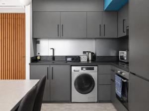 a kitchen with a washing machine and a table at Kay-Stay in Larnaca