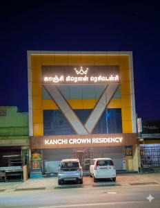 two cars parked in a parking lot in front of a building at Kanchi Crown Residency in Kanchipuram