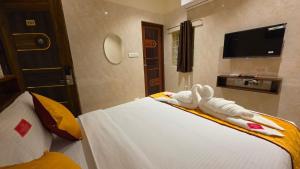 a hotel room with a bed with towels on it at Kanchi Crown Residency in Kanchipuram +6 photos