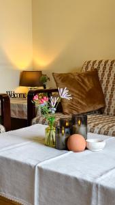 a white table with candles and flowers on a bed at Premium Villa Tode in Bansko