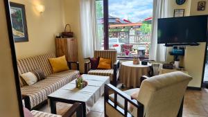 a living room with couches and a tv and a table at Premium Villa Tode in Bansko