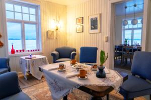 a living room with a table and blue chairs and a table and chairsktop at Villa Lofoten - The Farmhouse in Kvalnes