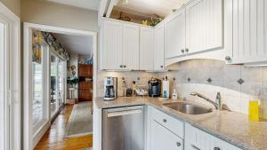 a kitchen with white cabinets and a sink at Bethany West - 702 Radial Dr in Bethany Beach