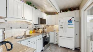 a kitchen with white cabinets and a white refrigerator at Bethany West - 702 Radial Dr in Bethany Beach