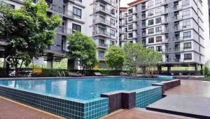 a swimming pool in front of some tall buildings at Living avenue condominuim in Ban Rong Khoei