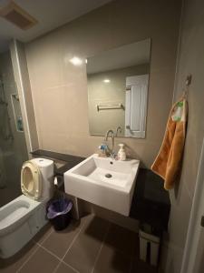 a bathroom with a white sink and a toilet at Living avenue condominuim in Ban Rong Khoei