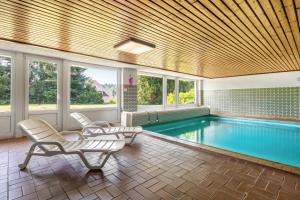 a swimming pool with two lounge chairs and avationliest at Beautiful Apartment in Häusern