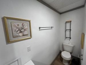 a bathroom with a toilet and a picture on the wall at Athens House nuber 8 in Las Vegas