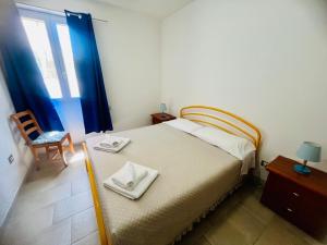 a bedroom with a bed with two towels on it at Appartamenti Abbaidda in Valledoria +137 photos