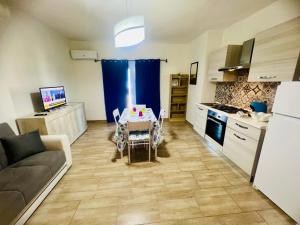a living room with a table and a kitchen at Appartamenti Abbaidda in Valledoria