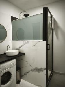 a bathroom with a sink and a washing machine at Apartamentos Joli in Olivares de Duero +45 photos
