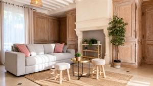 a living room with a couch and a fireplace at Le Jardin de Villevaudé, proche Disney & Paris in Villevaudé