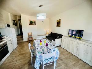 a kitchen and living room with a table and a couch at Appartamenti Abbaidda in Valledoria
