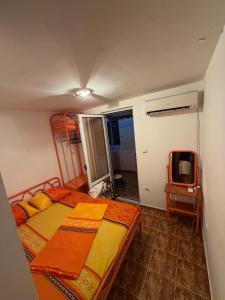 a small bedroom with a bed and a tv at ADM Apartment in Bečići