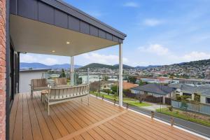 a wooden deck with a bench on a balcony at Modern Lindisfarne Escape in Lindisfarne