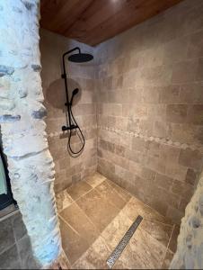 a bathroom with a shower with a stone wall at Domaine de Camentroun in Pomarez