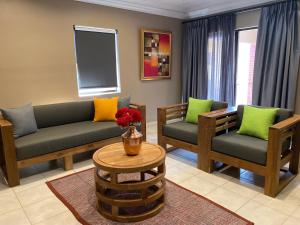 a living room with a couch and two chairs and a table at Ntaba Villas in Port St. Johns