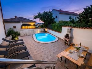 a backyard with a swimming pool and a table and chairs at Apartments Villa Maria in Crikvenica