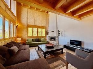 a living room with a couch and a table at Tschoueilles 009 MOUNTAIN & VIEW - chalet 12 pers in Veysonnaz