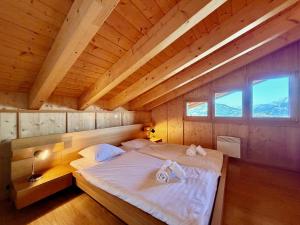 a large bed in a room with a wooden ceiling at Tschoueilles 009 MOUNTAIN & VIEW - chalet 12 pers in Veysonnaz