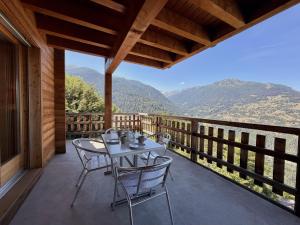 a table and chairs on a porch with a view of mountains at Tschoueilles 009 MOUNTAIN & VIEW - chalet 12 pers in Veysonnaz