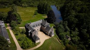 an aerial view of an old house with a river at Château de Saint-Pois in Saint-Pois