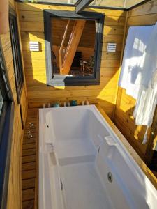 a tub in a tiny house with a window at Vale do Sossego- Cabana na Serra in Alfredo Wagner