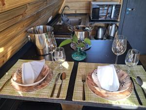 a table with two plates and wine glasses on it at Vale do Sossego- Cabana na Serra in Alfredo Wagner +4 photos