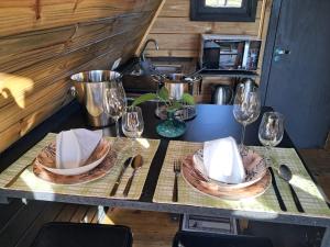a table with two plates and wine glasses on it at Vale do Sossego- Cabana na Serra in Alfredo Wagner