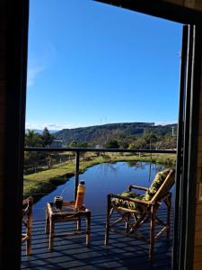 a view of a pond from the porch of a house at Vale do Sossego- Cabana na Serra in Alfredo Wagner