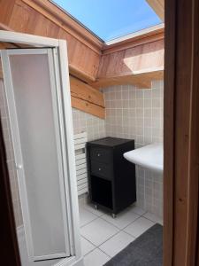 a bathroom with a shower and a sink and a mirror at Chalet Mary in La Côte dʼArbroz